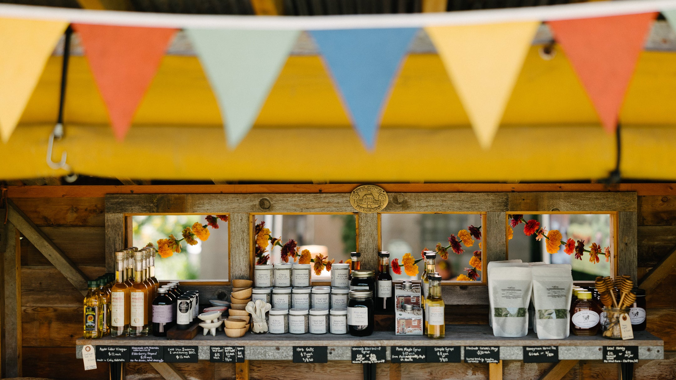 Abundantly stocked and vibrant farm stand shelf featuring farmer sourced, shelf-stable products, maples syrup, honey and more.